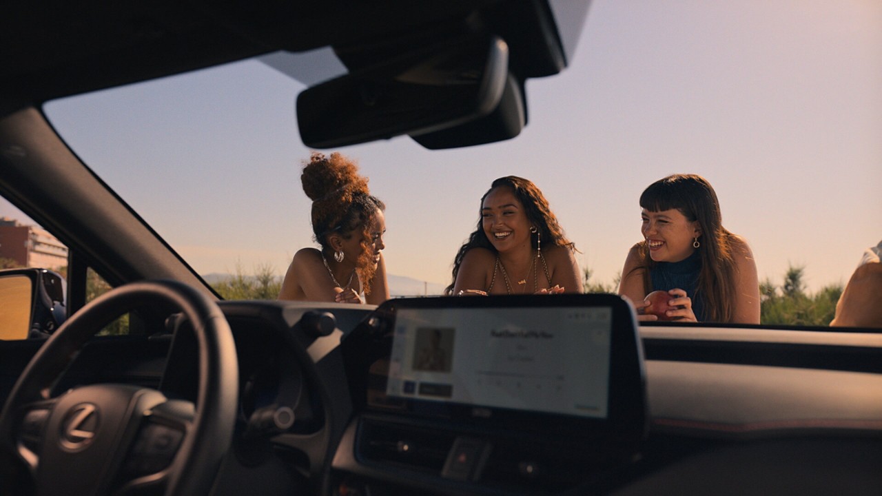 Joy Crookes leaning on the bonnet of a Lexus UX